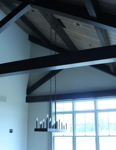 A living room with wood beams and windows.