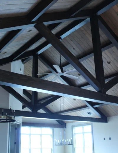 A living room with wood beams and a chandelier.
