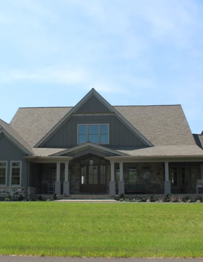 A home with a large front yard and a large front porch.