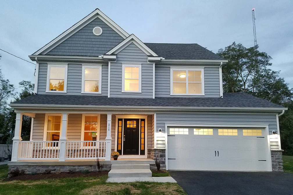 A two story home with a garage at dusk.
